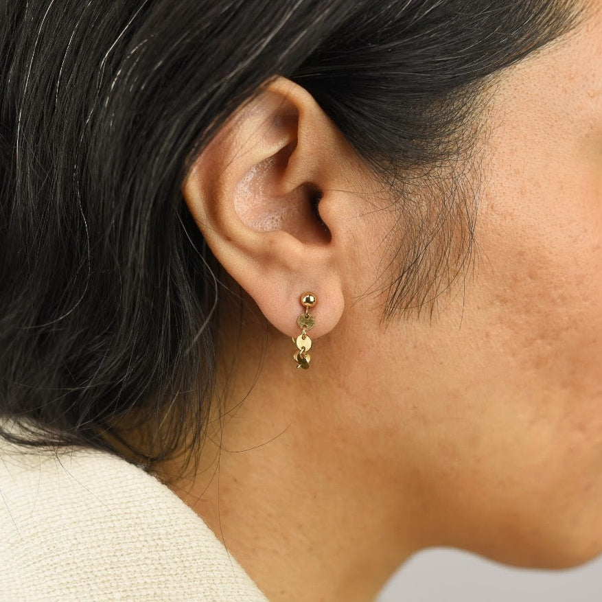 Close up image of a model wearing 14K gold fill Disc Chain Loop Earrings from Zurina Ketola