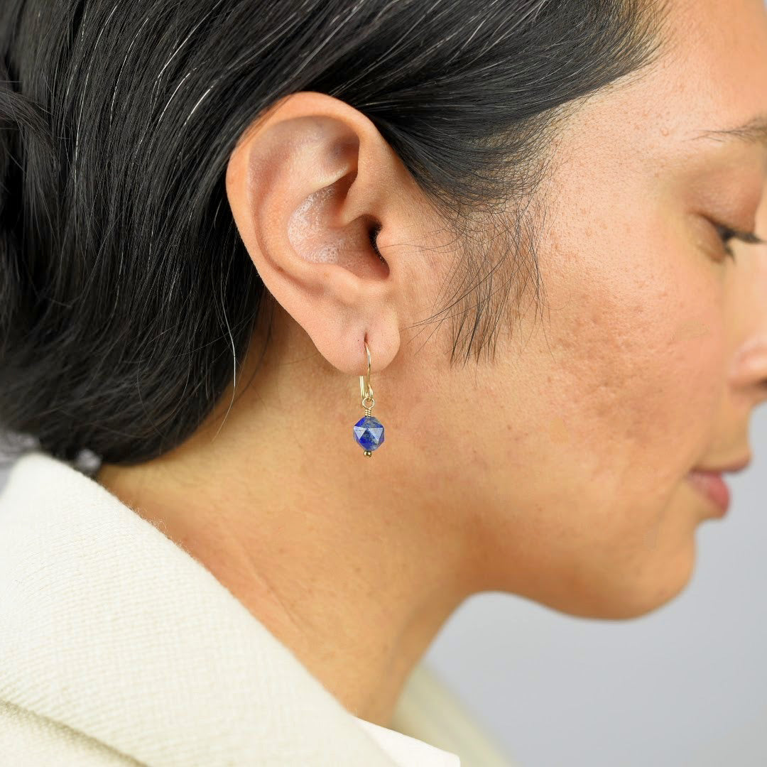 Close up image of a model wearing 14K gold fill Rose Cut Lapis Earrings from Zurina Ketola