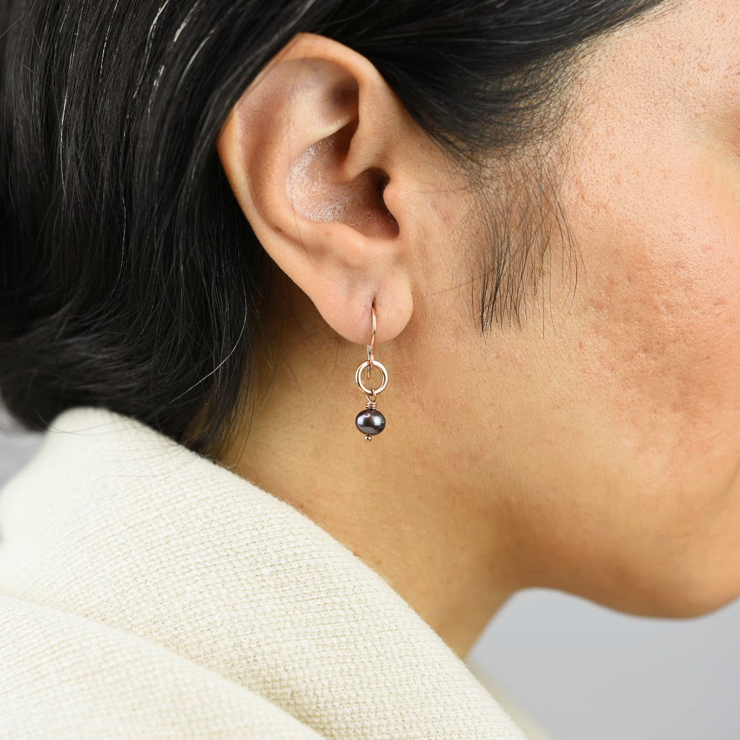 Close up image of a model wearing 14K rose gold fill Navy Pearl Link Drops from Zurina Ketola