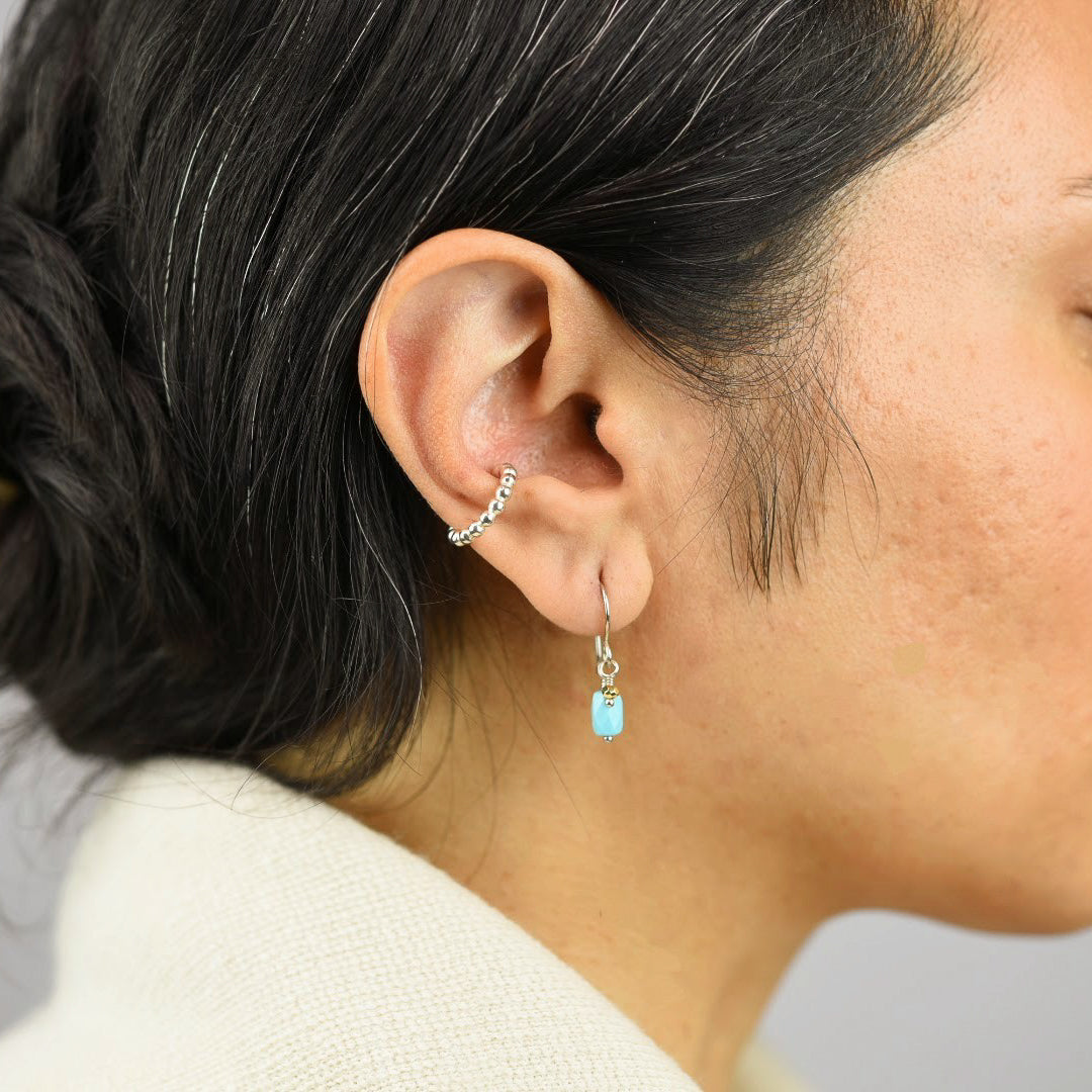 Close up image of a model wearing sterling silver Mix Metal Turquoise Earrings from Zurina Ketola