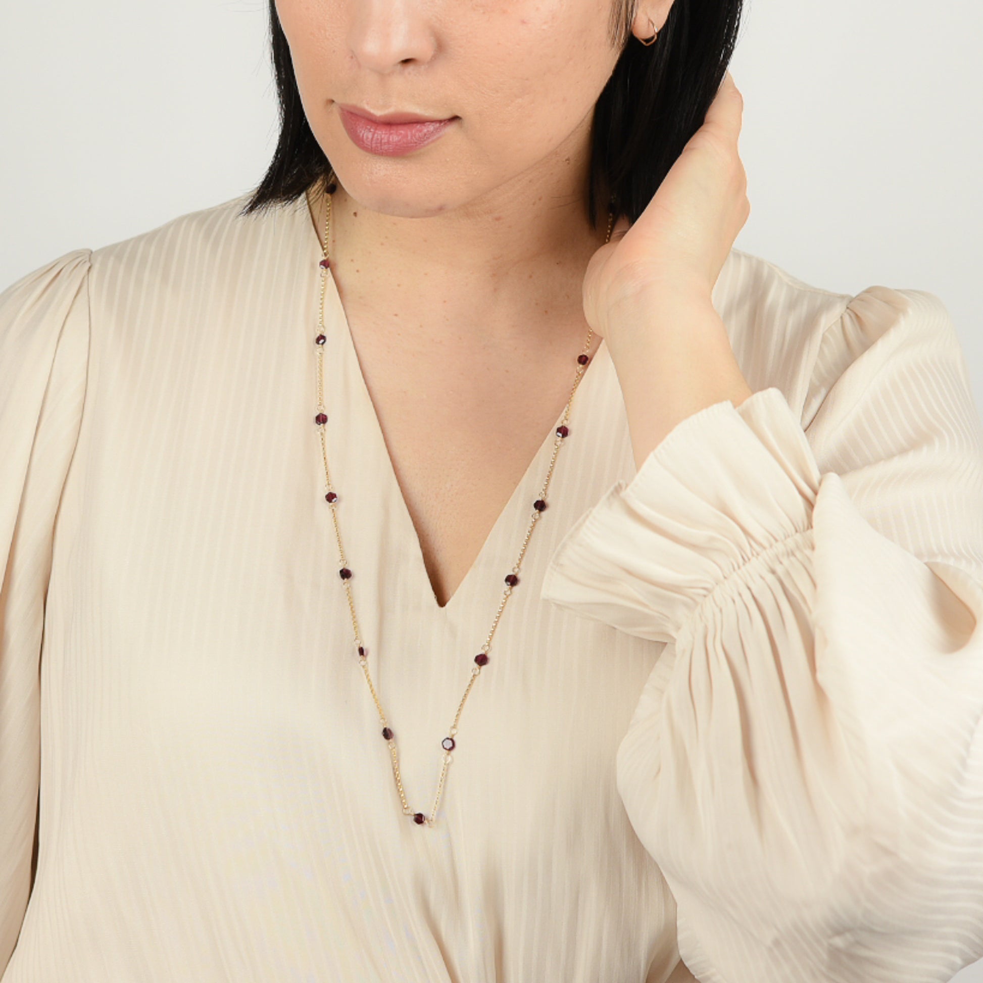 Model wearing upcycled garnet hexagon necklace long.