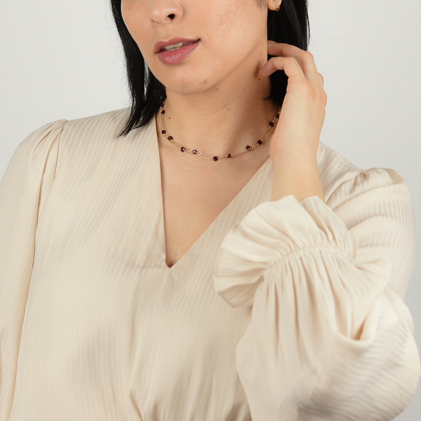 Model wearing upcycled garnet hexagon necklace as a double choker