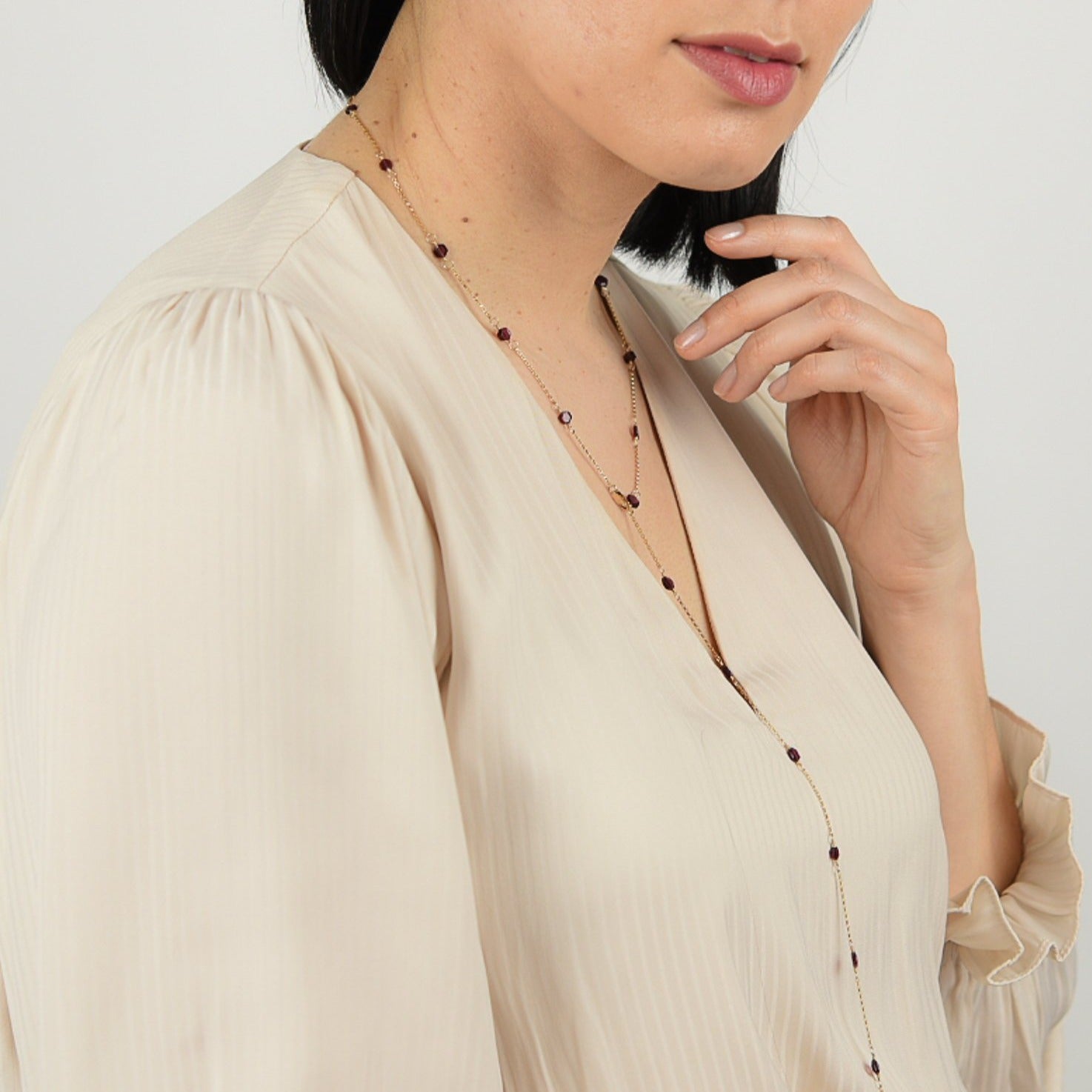 Model wearing upcycled garnet hexagon necklace in lariat style.