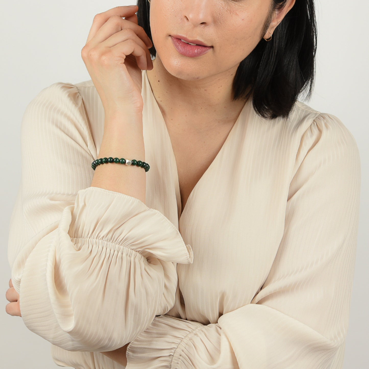 Model wearing malachite gemstone bracelet.