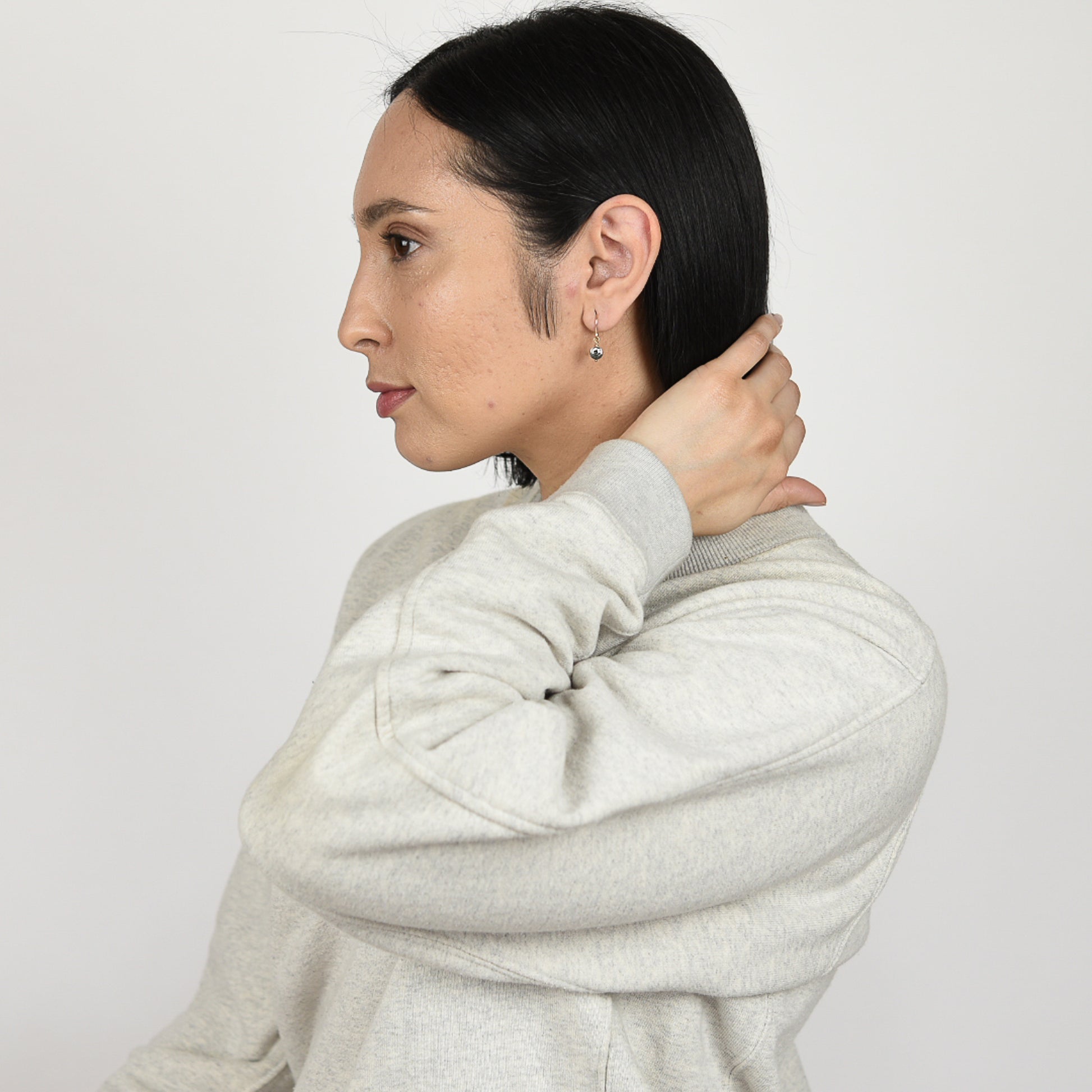 Close up image of a model wearing 14K gold filled Abalone Delicate Star Facet Earrings from Zurina Ketola