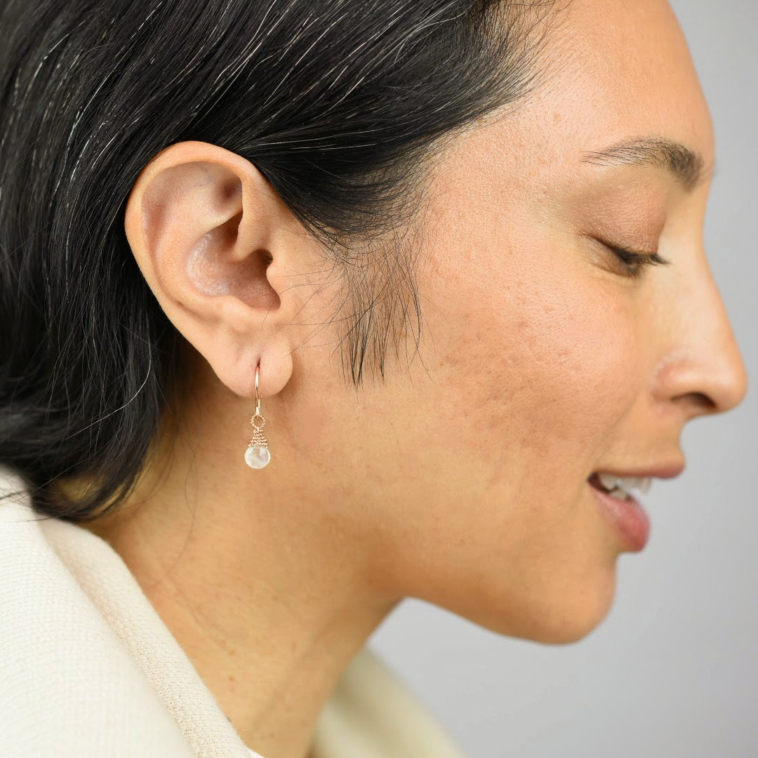  Close up image of a model wearing 14K rose gold fill Rainbow Moonstone Earrings from Zurina Ketola