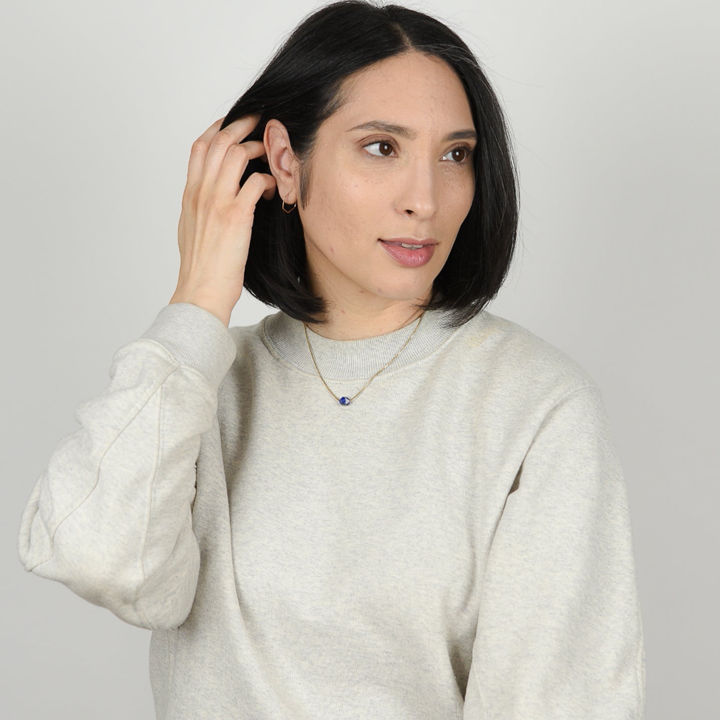 Model wearing hexagon hoop earrings and rose cut lapis necklce.