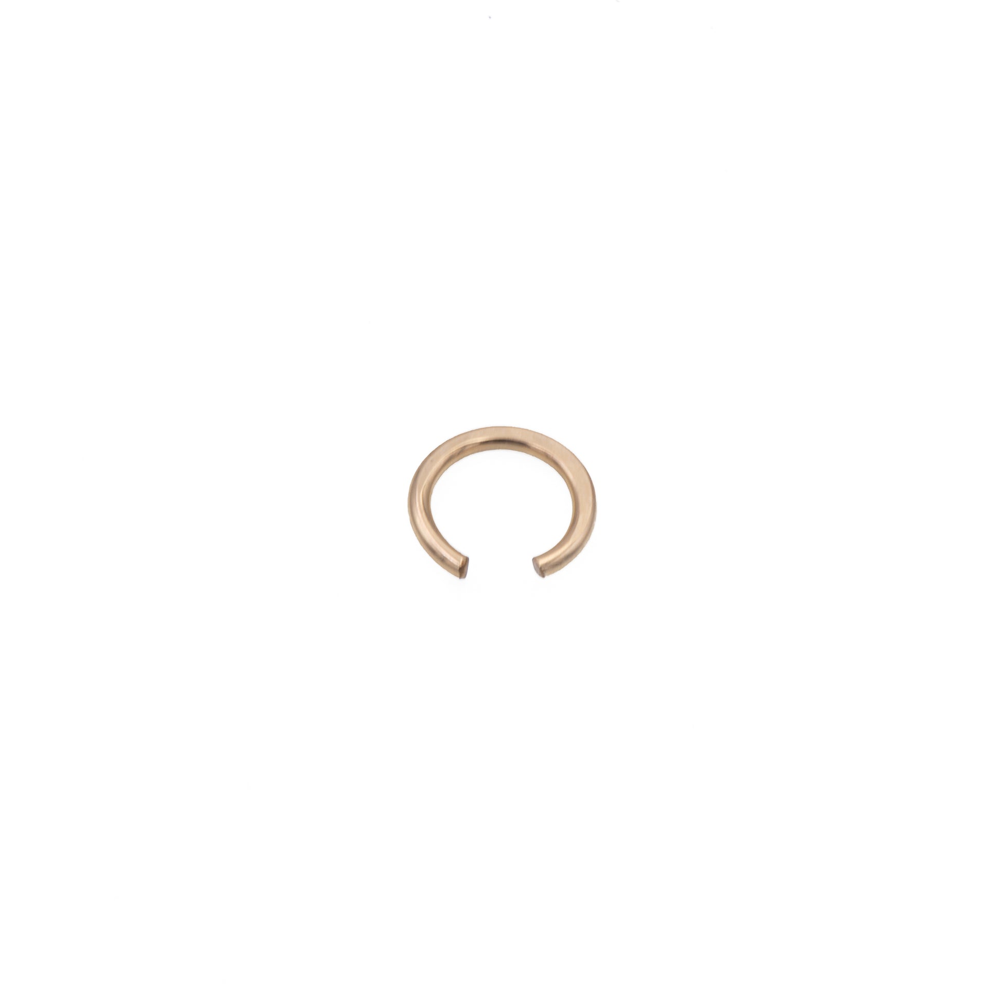 Zurina Ketola simple ear cuff in 14K gold fill, viewed from above at a slight angle, on white background.